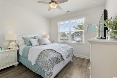 Bedroom with dark wood-type flooring, baseboards, and a ceiling fan