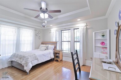 Bedroom with wood-type flooring, ceiling fan, a ra