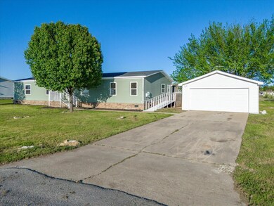 View of front of property featuring a front lawn and a garage