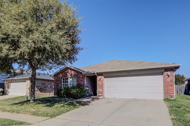 Single story home featuring brick siding, a front yard, driveway, and a shingled roof
