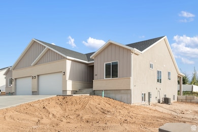 View of front of home featuring board and batten siding, an attached garage, a shingled roof, concrete driveway, and brick siding