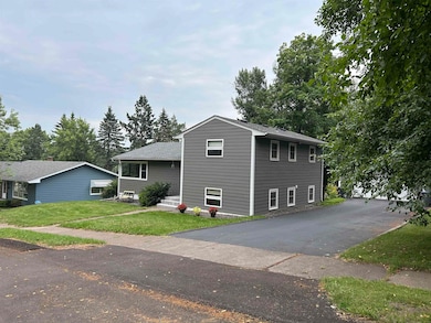 Split level home with a front lawn and a shingled roof