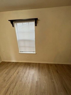 Unfurnished room featuring hardwood / wood-style f