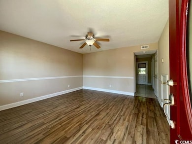 Empty room with a ceiling fan, dark wood finished 