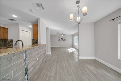Unfurnished living room with a chandelier, ceiling fan, wood tiled floors, and recessed lighting