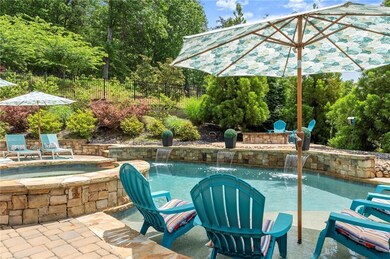 View of swimming pool featuring fence, a patio area, and a pool with connected hot tub