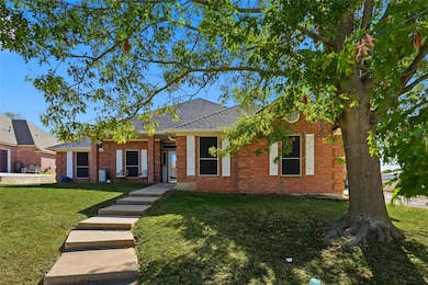 Single story home featuring a front yard, a shingled roof, and brick siding