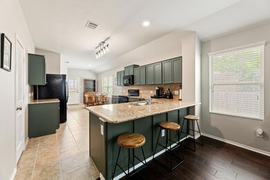 Kitchen with black appliances, lofted ceiling, a 