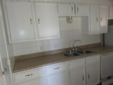 Kitchen with backsplash, white cabinetry, light stone countertops, dishwasher, and sink