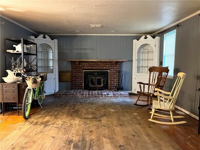 Living room with woodburning fireplace and built in cabinets.