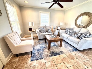 Living room featuring baseboards, crown molding, a