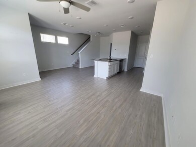 Unfurnished living room with stairs, ceiling fan,