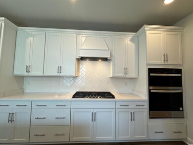Kitchen featuring custom range hood, appliances wi
