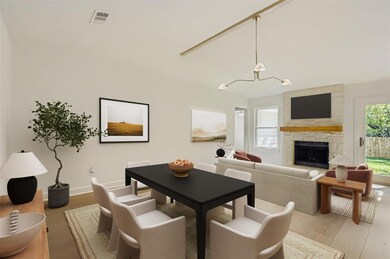Dining room with a fireplace, wood finished floors, and a chandelier