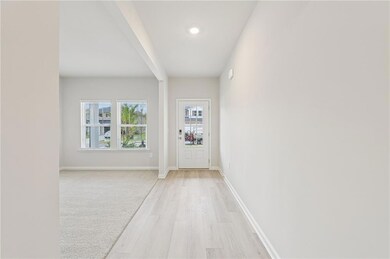 Hall featuring light wood-type flooring and light colored carpet