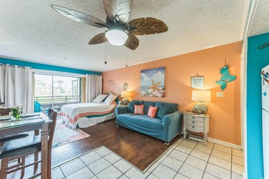 Bedroom featuring a textured ceiling, light tile patterned flooring, a ceiling fan, and baseboards