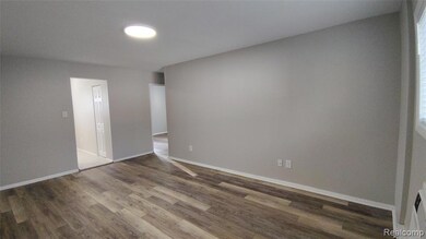 Spare room featuring light wood-style floors and baseboards