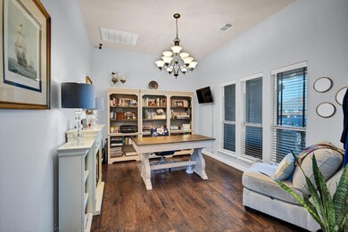 Office space with dark hardwood / wood-style flooring and an inviting chandelier
