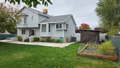 Back of property with a patio, a fenced backyard, a vegetable garden, and roof with shingles