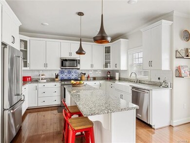 Custom white cabinets, granite counters, farmhouse sink, wine cooler, Kitchen Aid appliance with gas stove