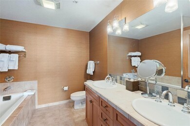 Bathroom with tile patterned floors, tiled bath, t