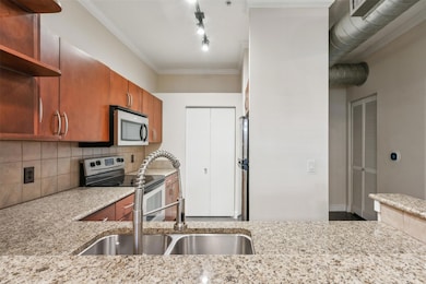 Kitchen featuring light stone counters, appliances