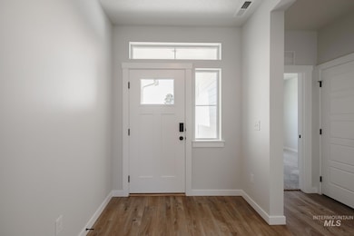 Entrance foyer with baseboards and light wood-type flooring