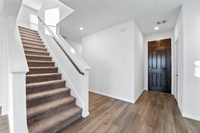Walking into this gorgeous home, you get a feel of just how warm and open everything is, this entryway features high ceilings, recessed lighting, gorgeous vinyl plank flooring, custom paint, and a covenient coat closet.
