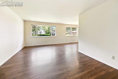 Empty room featuring dark wood-style flooring and baseboards