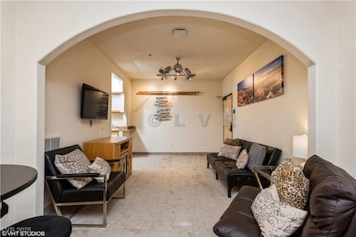 Living room featuring arched walkways, carpet, and visible vents