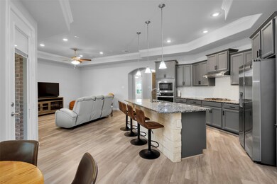 Central, island kitchen is open to the living and dining spaces
