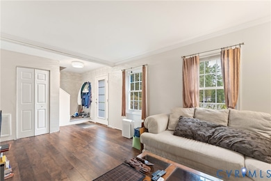 Living room with wood finished floors and ornamental molding