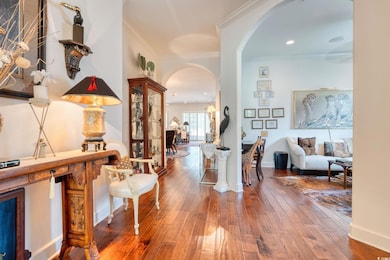 Hall featuring arched walkways, wood-type flooring, ornamental molding, and recessed lighting