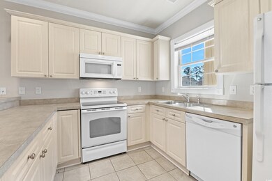 Kitchen with light tile patterned floors, white ap
