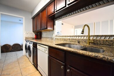 Kitchen featuring white dishwasher, a sink, washin