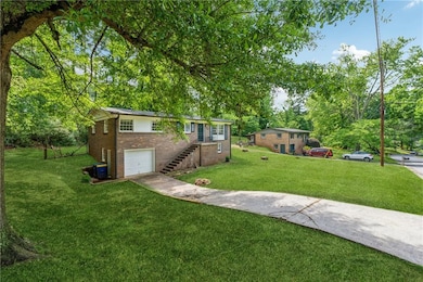 View of yard with a garage, concrete driveway, and
