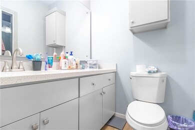 Bathroom featuring vanity, toilet, and baseboards