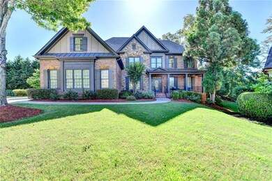 Craftsman-style home featuring board and batten siding, a front yard, brick siding, and covered porch