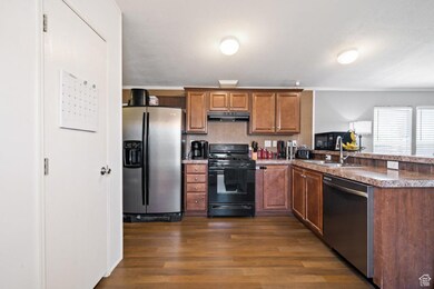 Spacious kitchen with plenty of prep space, double sinks, stainless steel refrigerator, gas range, and stylish wood cabinetry. A layout designed for real-life cooking and hosting!