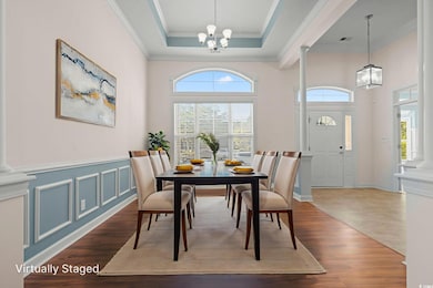 Dining space with decorative columns, a chandelier, LVF, crown molding, and a raised ceiling