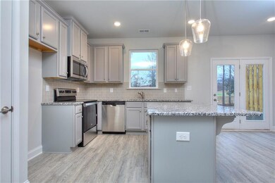Kitchen with stainless steel appliances, light wood-style floors, healthy amount of natural light, gray cabinets, and recessed lighting