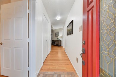 A bold and cheerful red front door with a leaded glass insert opens into this immaculately kept home with wood-look laminate floors leading down an extended hallway to the centrally located family room. To the left is a flex-use dining room, study, or 4th bedroom.