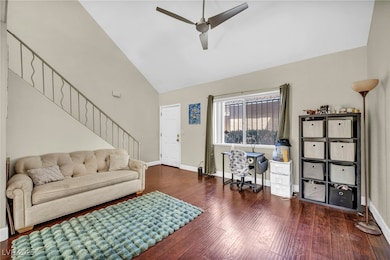 Living room featuring ceiling fan, baseboards, woo