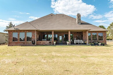 Rear view of house with a lawn, ceiling fan, and a