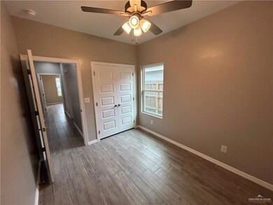 Unfurnished bedroom with baseboards, dark wood finished floors, and a ceiling fan
