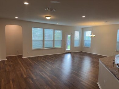 Unfurnished living room with a chandelier, arched