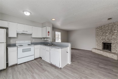 Kitchen featuring white appliances, a textured ce