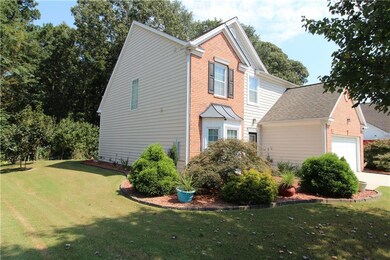 View of front of property featuring a front yard, brick siding, and a garage