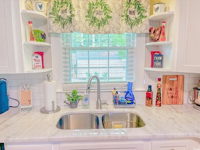 Kitchen with sink, white cabinets, and decorative 
