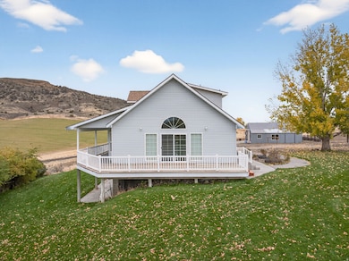 Back of house featuring a wooden deck and a yard